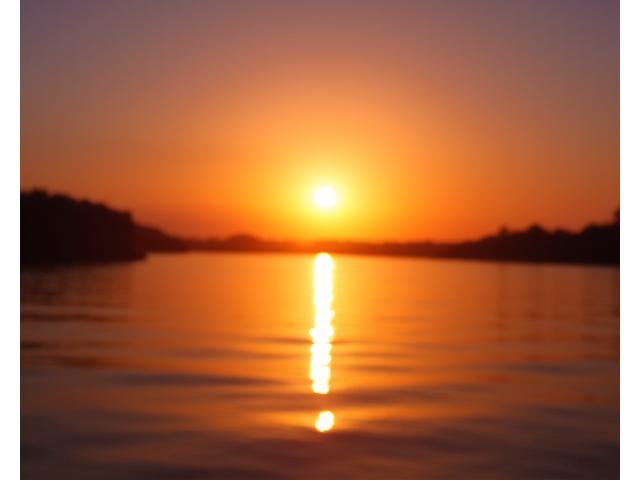 Pescador al atardecer en un lago, representando el verano.